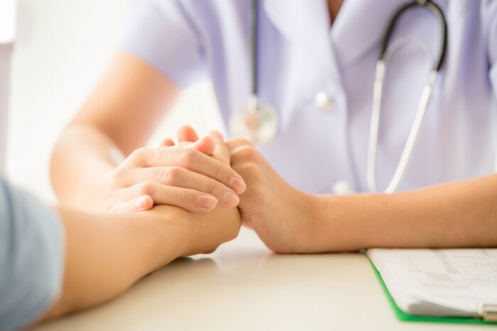 Female psychologist consulting patient at the desk in hospital.
